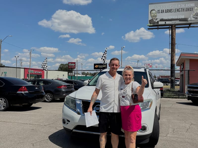 Happy couple receiving car keys at Jeffrey's Auto Sales